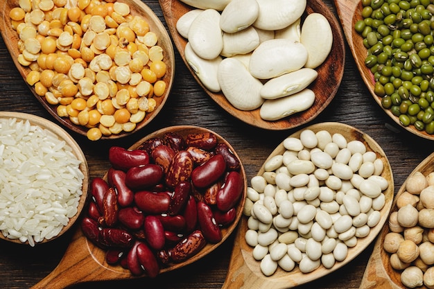 Dried beans in wooden spoons on the table, close up