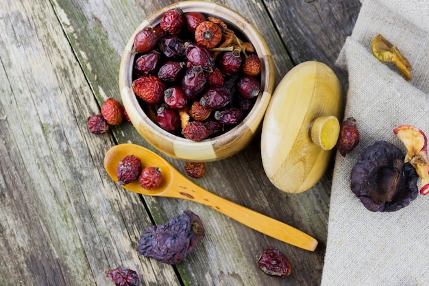 Dried berries in a wooden pot with a spoon on the table