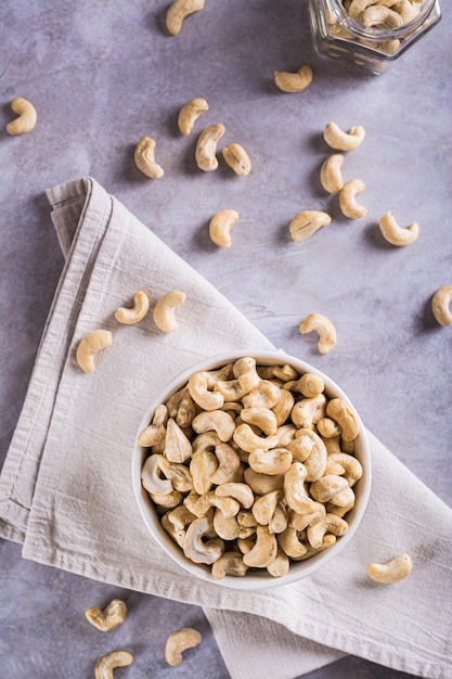 Dried cashew nuts in a bowl on the table for a vegetarian diet top and vertical view