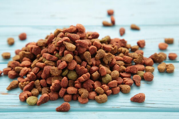 Dried cat food shaped kitty kibble as an abstract background texture on blue wooden background