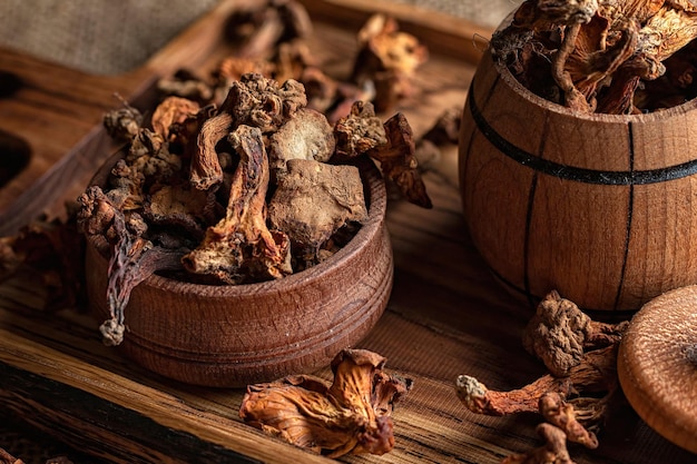 Dried chanterelle mushrooms Cantharellus cibarius on a wooden board on a rough woven background burlap