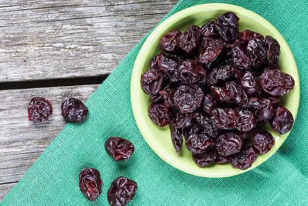 Dried cherries in a clay plate on a wooden table in a rustic style