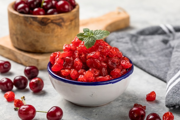 Dried cherries with fresh berry  on a white surface