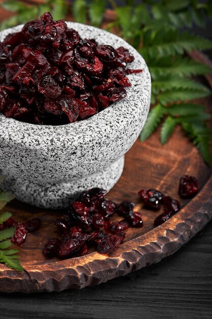 Photo dried cherry in a bowl over gray background top view