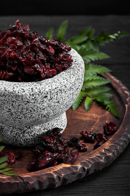 Photo dried cherry in a bowl over gray background top view