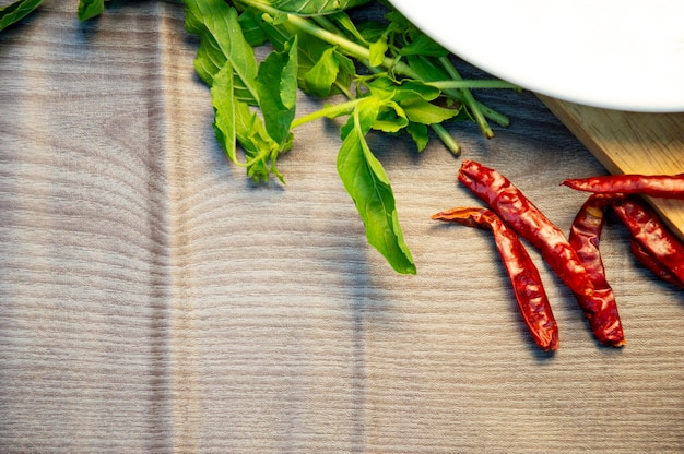 Dried chillies basil leaves on wooden background