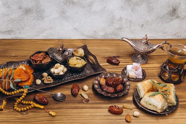 Dried dates and tea on a wooden table Arabic traditional dishes pots and dates fruits Ramadan Kareem Eid mubarak concept Copy space