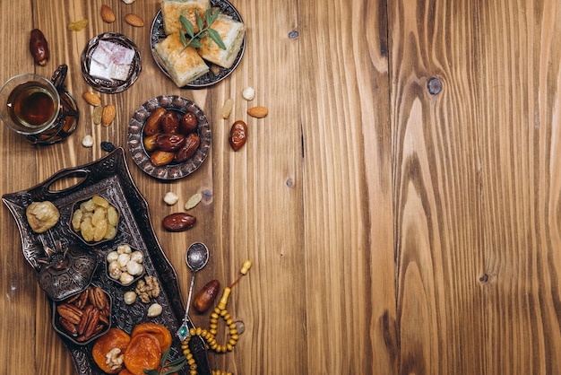 Dried dates and tea on a wooden table Arabic traditional dishes pots and dates fruits Ramadan Kareem