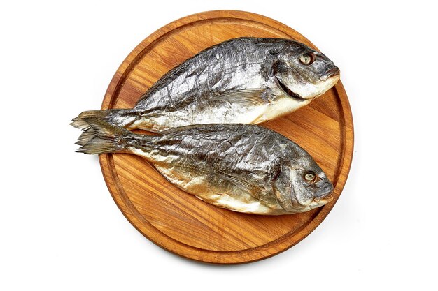 Dried dorado fish on a wooden board Closeup selective focus White background