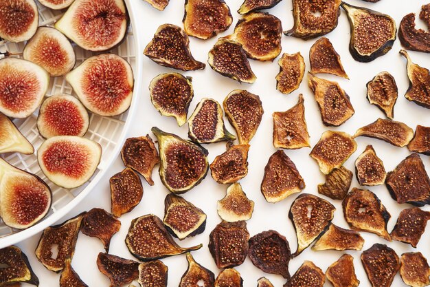 Dried figs lie next to fresh ones on a plate on the table