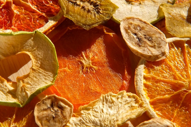 Dried fruits Assorted of healthy sundried organic fruit flat lay on wooden background Snacking and baking Trendy Mix of dried and candied fruit slices Top view close up Sunlight hard shadows