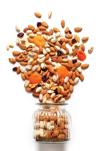 Dried fruits and nuts mixed and glass jar Concept of the Jewish holiday Tu Bishvat on white background with copy space