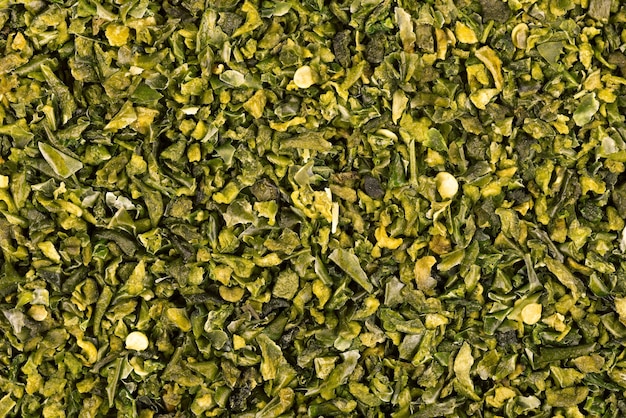 Dried green paprika flakes with seeds background. Chopped jalapeno, habanero or chilli pepper. Spices and herbs.