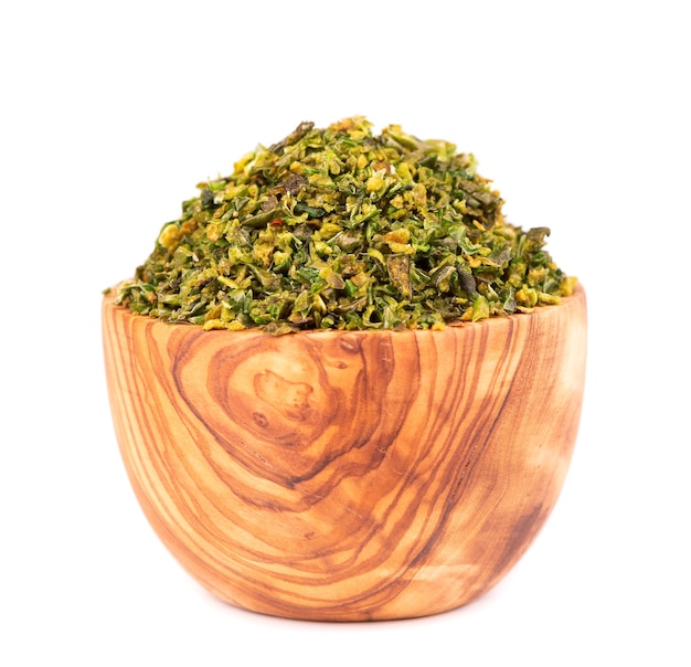 Dried green paprika flakes with seeds in olive bowl, isolated on white background. Chopped jalapeno, habanero or chilli pepper. Spices and herbs.