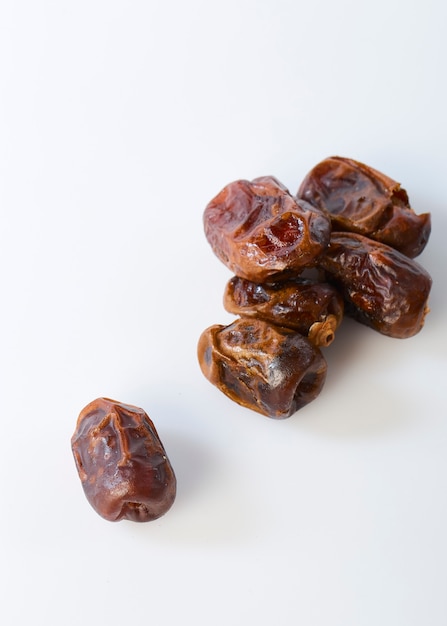 Dried halawi dates on a white