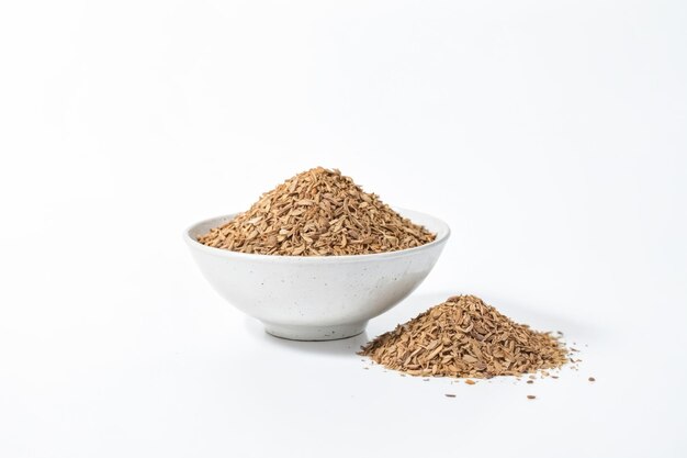 Dried herb in a white bowl on white background