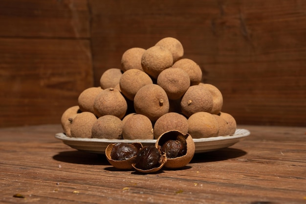 Dried longan in the container on the wood grain table