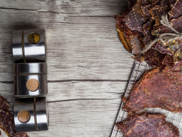 Dried meat slices with spices in jars copy space