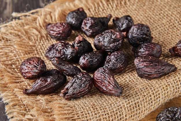 Dried mission figs on burlap and wooden background