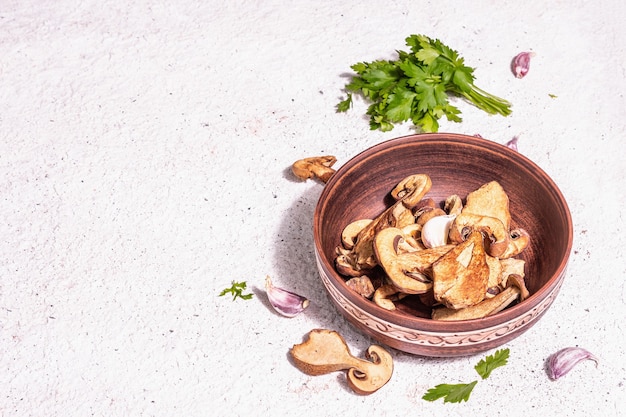 Photo dried mushrooms boletus edulis (penny bun, cep, porcini) on textured plaster background. ingredient for vegetarian (vegan) healthy food. a trendy hard light, dark shadow, copy space