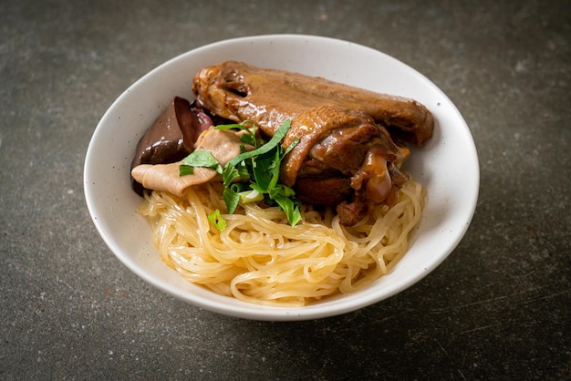 Dried noodles with braised duck in white bowl