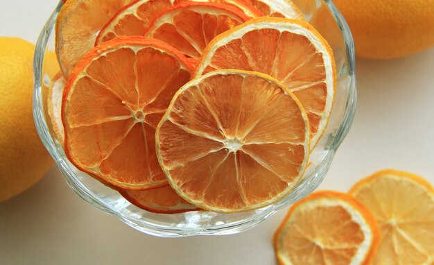 dried orange and lemon slices in a bowl with fresh lemon