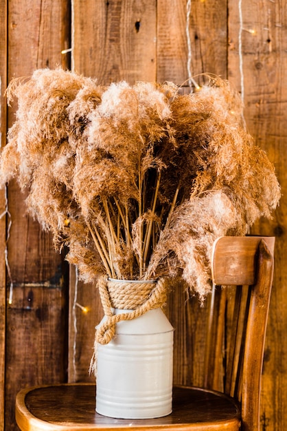 Dried Pampas Grass in White Vase on Wooden Background