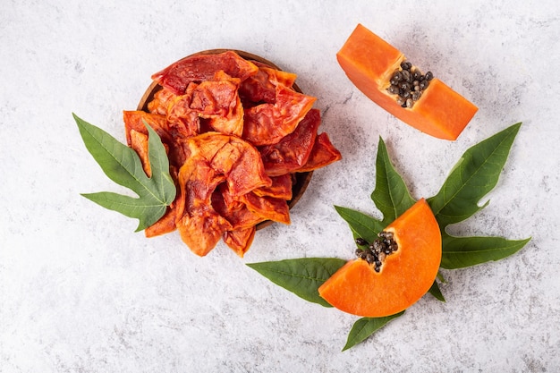 Dried papaya slices on white background top view.