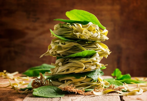 Dried pasta with fresh spinach old wooden background selective focus