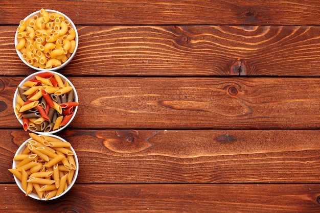 Dried pasta on wooden background