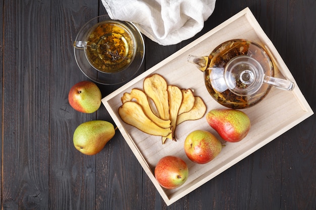 Dried pears with tea on a wooden tray