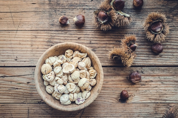 Dried peeled chestnuts on wooden background