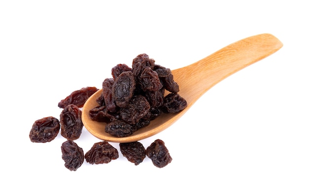 Dried raisins in spoon on white background