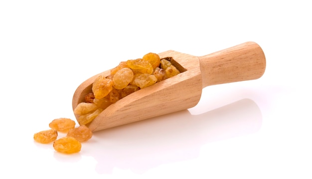 Dried raisins in wood scoop