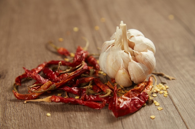 Dried red chili pepper and garlic cloves on a table close up