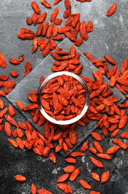 Dried red goji berries on gray background useful and healthy food concept flat layout with the place