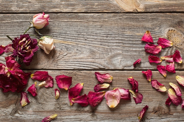 Dried rose petals on wooden table