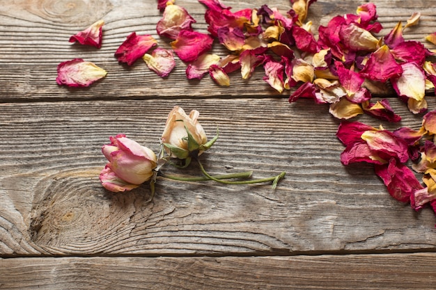 Dried rose petals on wooden table