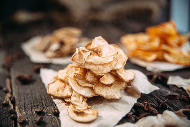 Dried slices of apple on paper close up view