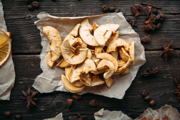 Dried slices of apple on paper top close up view.