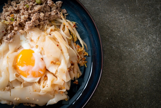 Dried spicy noodles with minced pork meatballs and egg Asian food style