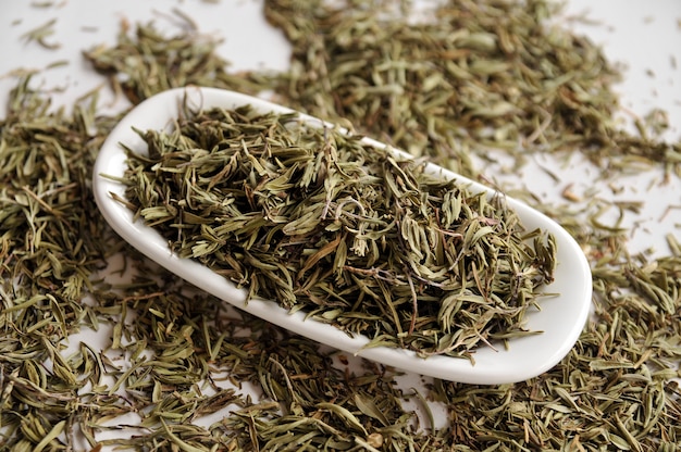 Dried thyme in a white bowl on a table