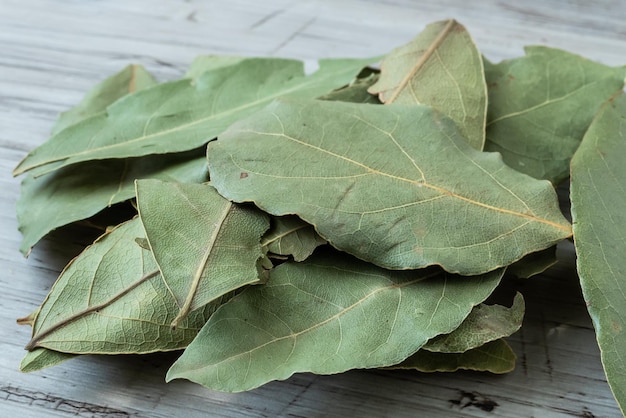 Dried whole bay leaves on cutting board Laurus nobilis