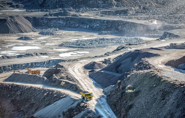 Drilling and crushing machines and mining truck working in stone quarry top view