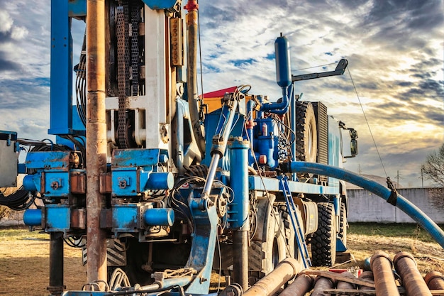 The drilling rig closeup is drilling a well against the background of the cloudy sky Deep hole drilling Geological exploration work mineral exploration Extraction of gas and oil