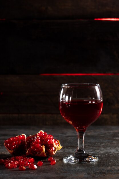 a drink of red color on the dark with pomegranate