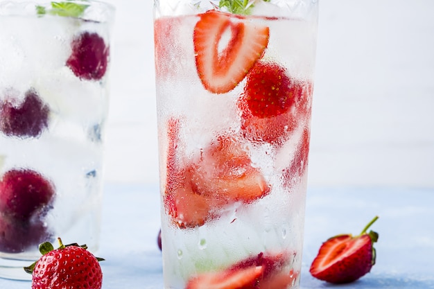 drink with strawberry, lime, cherry and mint. summer lemonades or ice tea. Mojito cocktails with ice cubes.