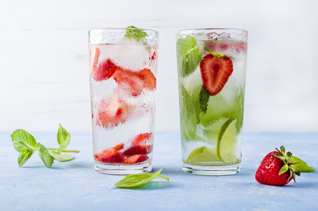 drink with strawberry, lime, and mint. summer lemonades or ice tea. Mojito cocktails with ice cubes.