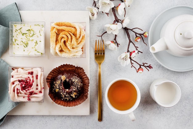 Drinking afternoon tea with sweet desserts Plate with different pieces of cakes