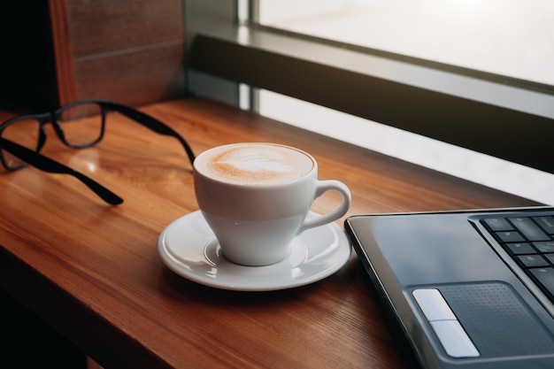 Drinking coffee while using a laptop in cafe